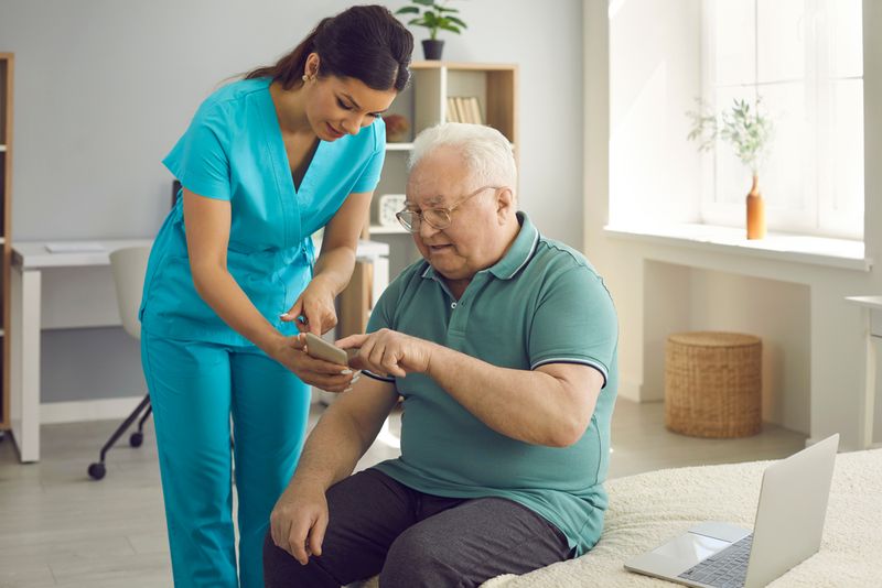 A healthcare professional showing a participant a program on a phone